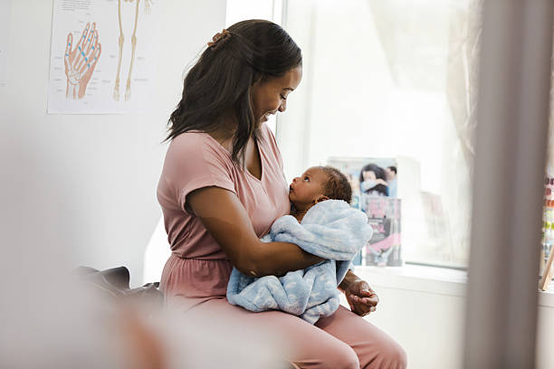 istock Mother lovingly holds her newborn baby in doctor's office 2209560408