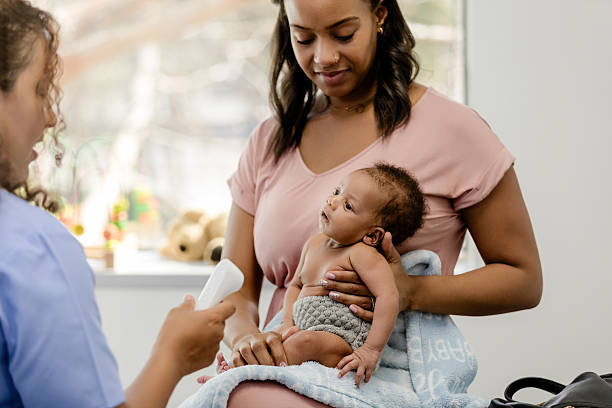 istock Mother Holding Baby During Doctor's Visit 2209560434