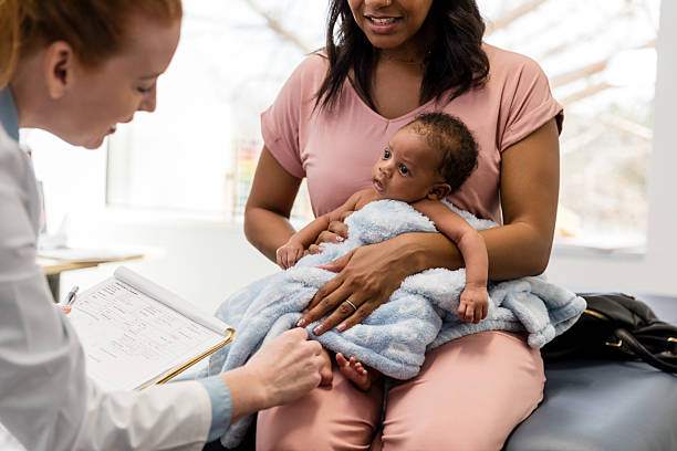 istock Baby's First Checkup: Doctor Examining Infant with Mother 2209560495