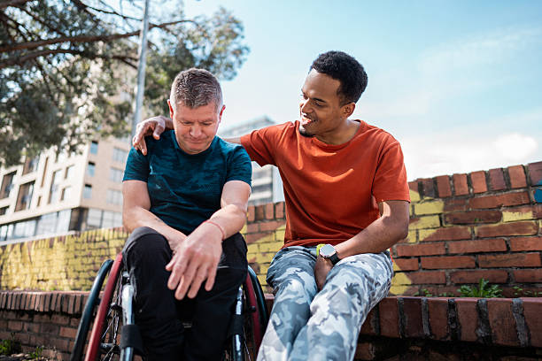 Male friends talking outdoors - including wheelchair man