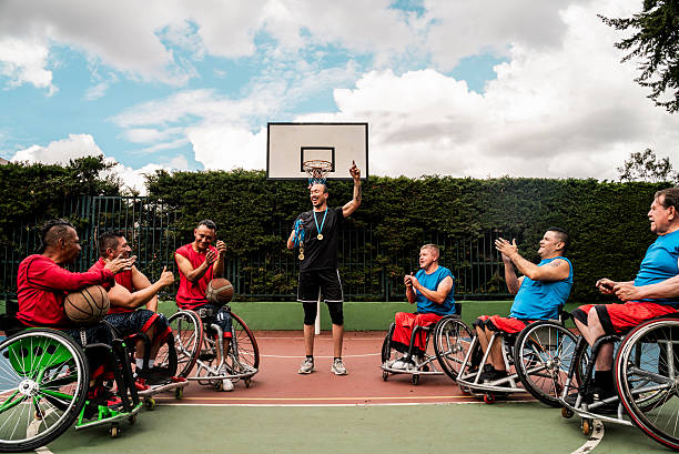 Instructor talking with athletes on a sports court - including wheelchairs athletes