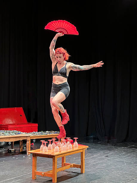 Female circus artist balancing on glass cups during a show