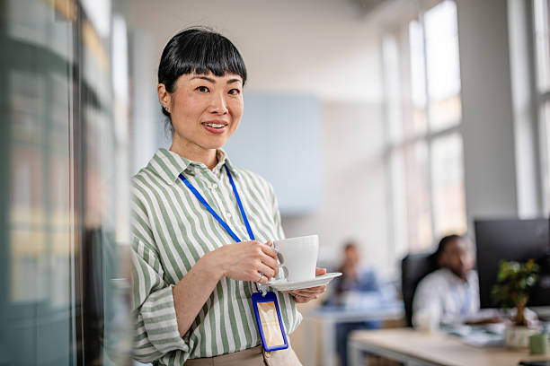 istock Smiling woman in modern office environment enjoying a coffee break while contributing to a diverse and collaborative workspace 2209570481