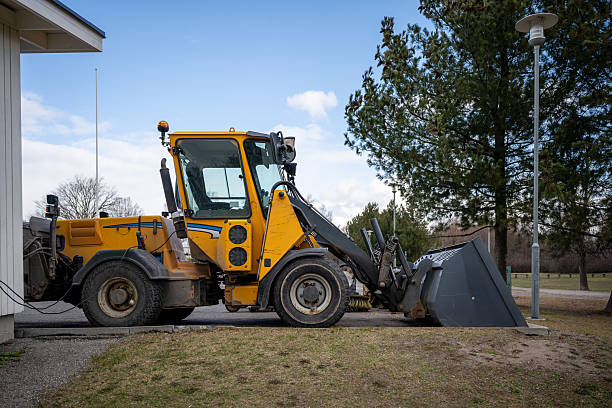 istock Yellow front loader parked by roadside near forested area 2209571727