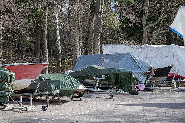 istock boats covered with tarps and plastic sheets, parked on trailers in outdoor, winter storage concept 2209574978