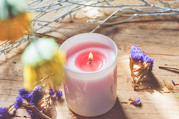 Candle and flowers in background on wooden table, part of mental health routine  - concepts and ideas, lifestyles and wellbeing