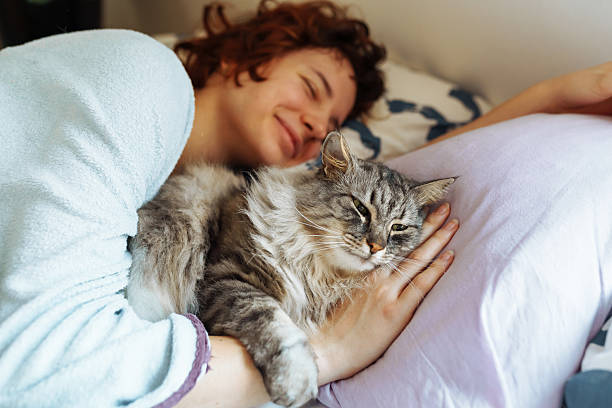 istock sleeping young woman on bed with pet cat 2209579555