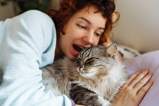 istock sleeping young woman on bed with pet cat 2209580177