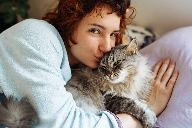 istock sleeping young woman on bed with pet cat 2209581040