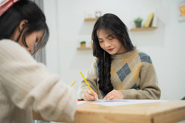 istock Two young women engaging in creative artistic activity, sketching and drawing together in a cozy indoor environment, focusing on their creative expressions and fun. 2209582051