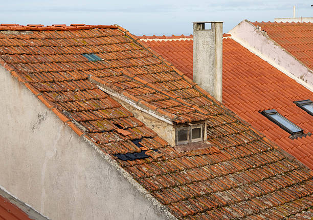A close-up view of the charming terracotta rooftops and historic buildings in Lisbon's Alfama district, captured under the warm morning sunlight.