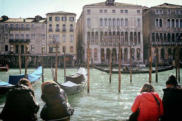 Venice, Italy - June 24, 2025: Gondola gliding through Venice canals, surrounded by colorful architecture and tranquil waters, embodying Italian charm and scenic beauty