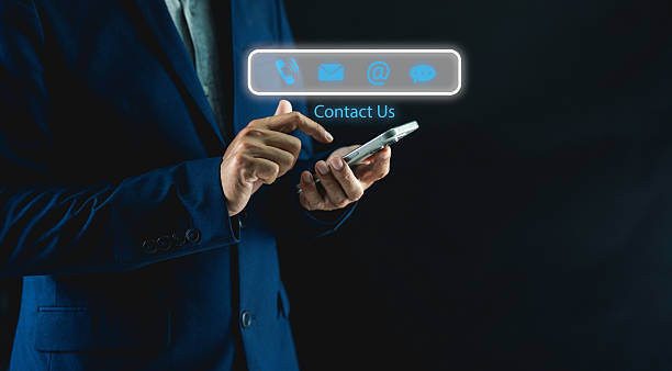 istock Businessman in a suit interacts with a smartphone, displaying contact options, symbolizing modern communication and business connectivity. 2209582973
