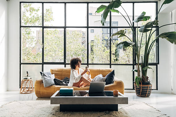 istock Young woman relaxing on sofa using smartphone in modern apartment 2209583602