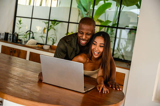 istock Couple enjoying time together browsing on a laptop in a modern kitchen space 2209584620