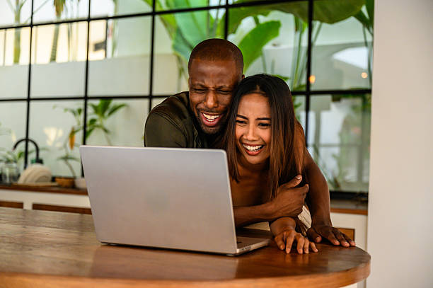 istock Cheerful couple happily sharing a moment while browsing the internet on a laptop 2209584625