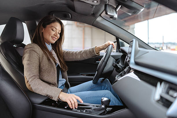 istock Beautiful woman adjusting vehicle controls while seated in a modern car 2209586960