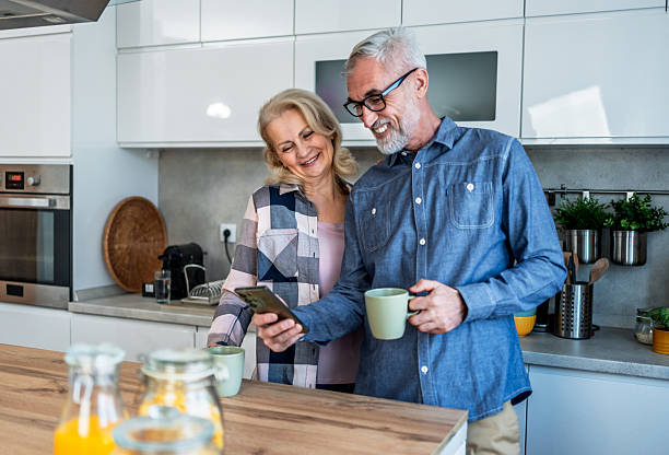 istock Mature couple using smartphone in the kitchen 2209589905