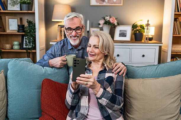 istock Senior couple using phone at home 2209589938