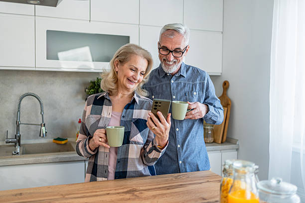 istock Mature couple using smartphone in the kitchen 2209590043