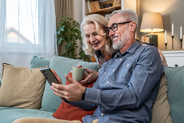 istock Senior couple using phone at home 2209590131
