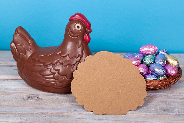 Easter chocolate chicken and eggs over a white rustic wooden table