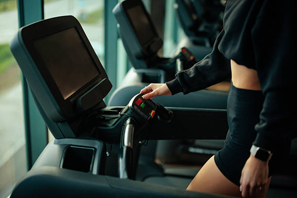 istock Woman starting treadmill workout in modern gym 2209591946