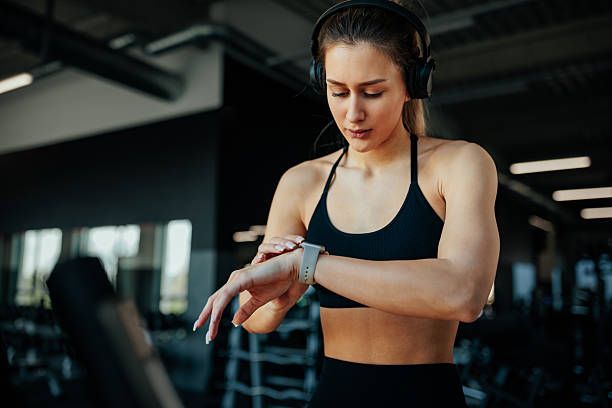 istock Young woman checking smart watch during workout at the gym 2209592081
