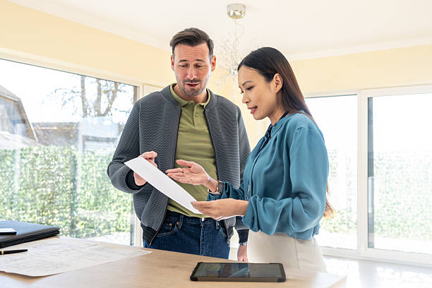 istock Professional Real Estate Agent Explains Property Details To Client In Bright Modern Office 2209592645