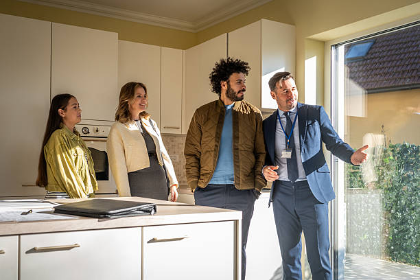 istock Diverse Young Family Exploring Modern Home with Real Estate Agent in Bright Kitchen Interior 2209592692