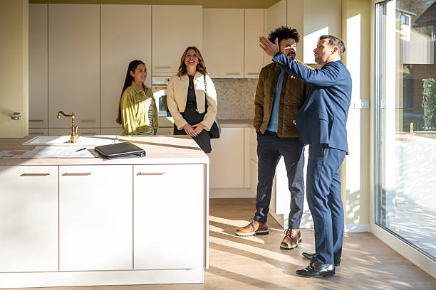 istock Diverse Young Family Exploring Modern Kitchen with Real Estate Agent in Bright Contemporary Home 2209592693