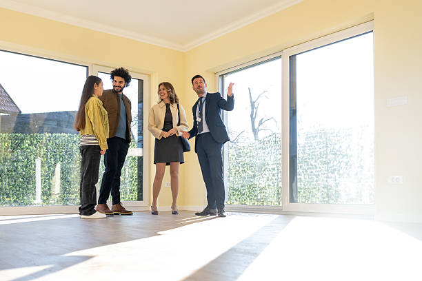 istock Professional Real Estate Agent Shows Bright Empty Room To Young Diverse Couple During Property Viewing 2209592714
