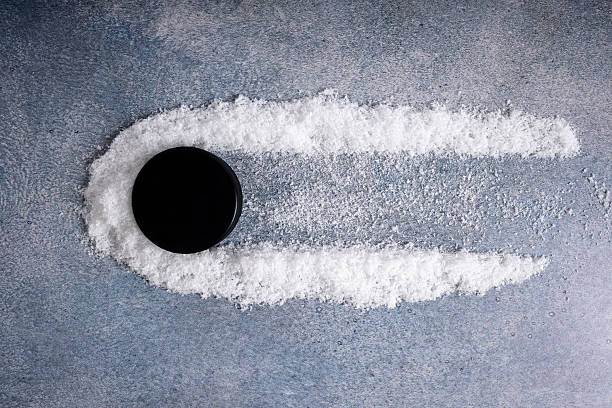 Shwoing motion of a hockey puck sliding across the ice, building up against the snow.
