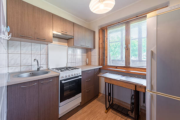 istock Modern Compact Home Kitchen Interior With Wooden Cabinets and Natural Light From a Large Window 2209595033