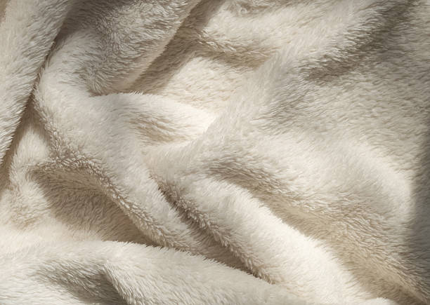 istock Beige soft eco-fur textile and textured pleats in sunlight, beautiful shadows 2209597953