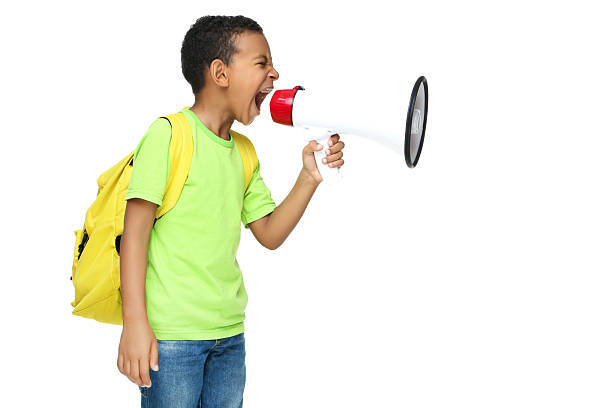 istock Young African American school boy screaming in megaphone with backpack on white background 2209598024