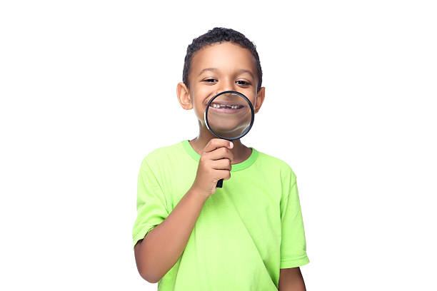 istock Young African American boy holding loupe isolated on white background 2209598418