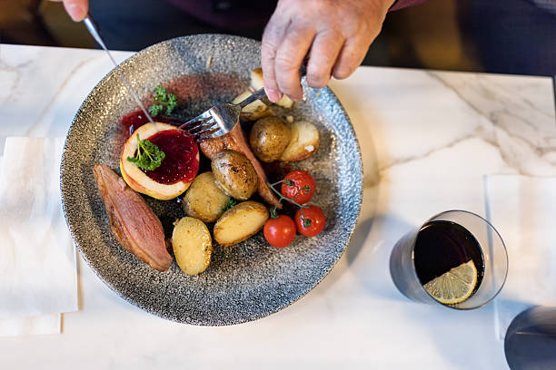 istock Senior man eating roasted potatoes, meat, and cherry tomatoes 2209598908