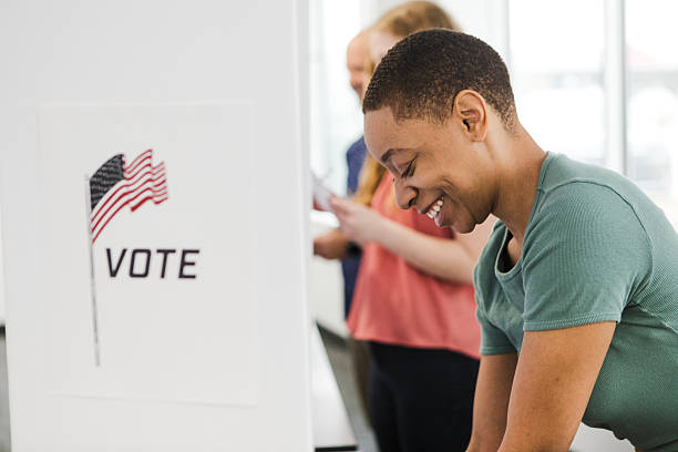 istock Happy Voter Casting Ballot at Polling Place 2209598972