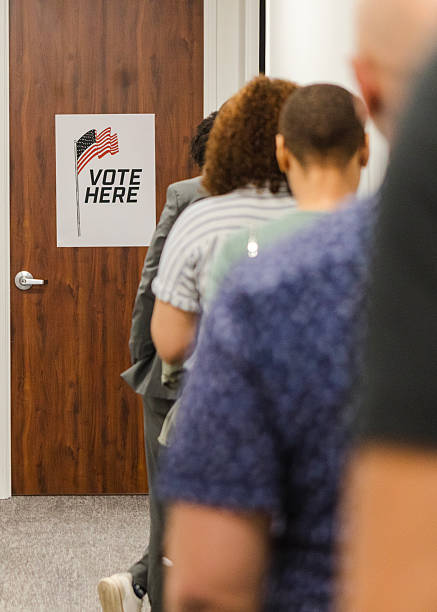 Citizens wait in line to vote.  Election day, voting rights.