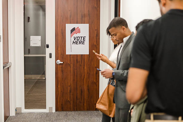 istock People Waiting in Line to Vote at Polling Place 2209598983