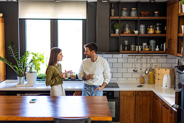 istock Couple drinking coffee and chatting in modern kitchen 2209600094