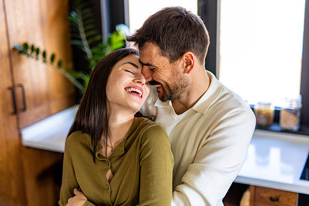 istock Happy couple laughing and embracing in kitchen 2209600528