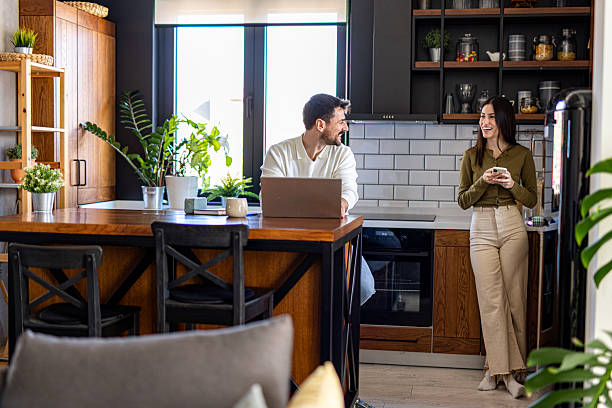 istock Couple enjoying morning in modern kitchen, working and using phone 2209603390