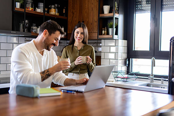 istock Couple enjoying coffee break while working from home in modern kitchen 2209603395