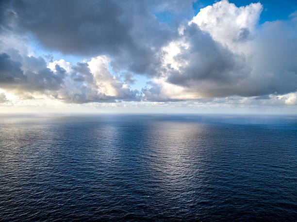 Aerial perspective capturing cloudy sunset reflections over seascape, revealing dramatic interplay of light and water in coastal Madeira, Portugal