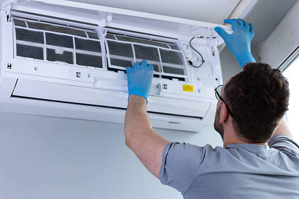 istock Individual Performing Routine Maintenance on Air Conditioning Unit While Wearing Blue Gloves, Ensuring Clean and Efficient Operation for Comfortable Indoor Environment 2209607224