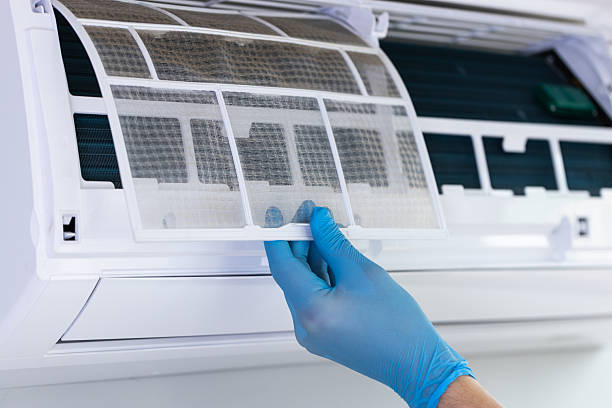 istock Detailing the Maintenance Process: Carefully Removing a Dusty Air Conditioner Filter with Gloved Hands for Efficient Cleaning and Optimal Performance Enhancement 2209609806