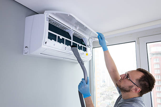 istock Professional Air Conditioning Maintenance: Man Cleaning and Servicing an AC Unit for Optimal Performance and Efficiency in Modern Indoor Environment 2209610533
