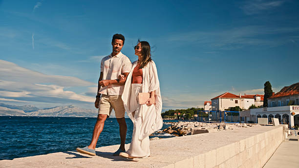 istock Elegant Diverse Couple Strolling Along Adriatic Coast Pier Under Clear Blue Sky 2209613986